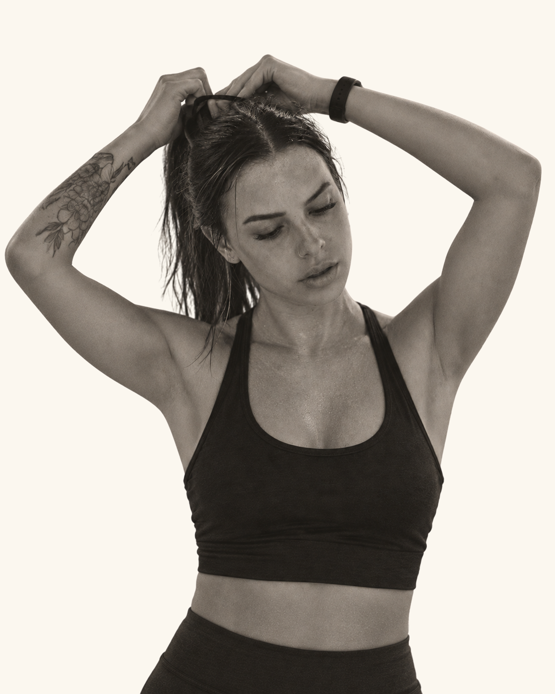 Woman tying her hair into a ponytail with both arms raised